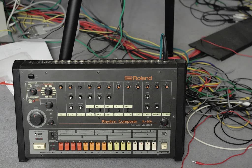 Front panel of a Roland TR-808 Rhythm Composer, showing per-voice level, tone, tuning and decay knobs above a row of step buttons.