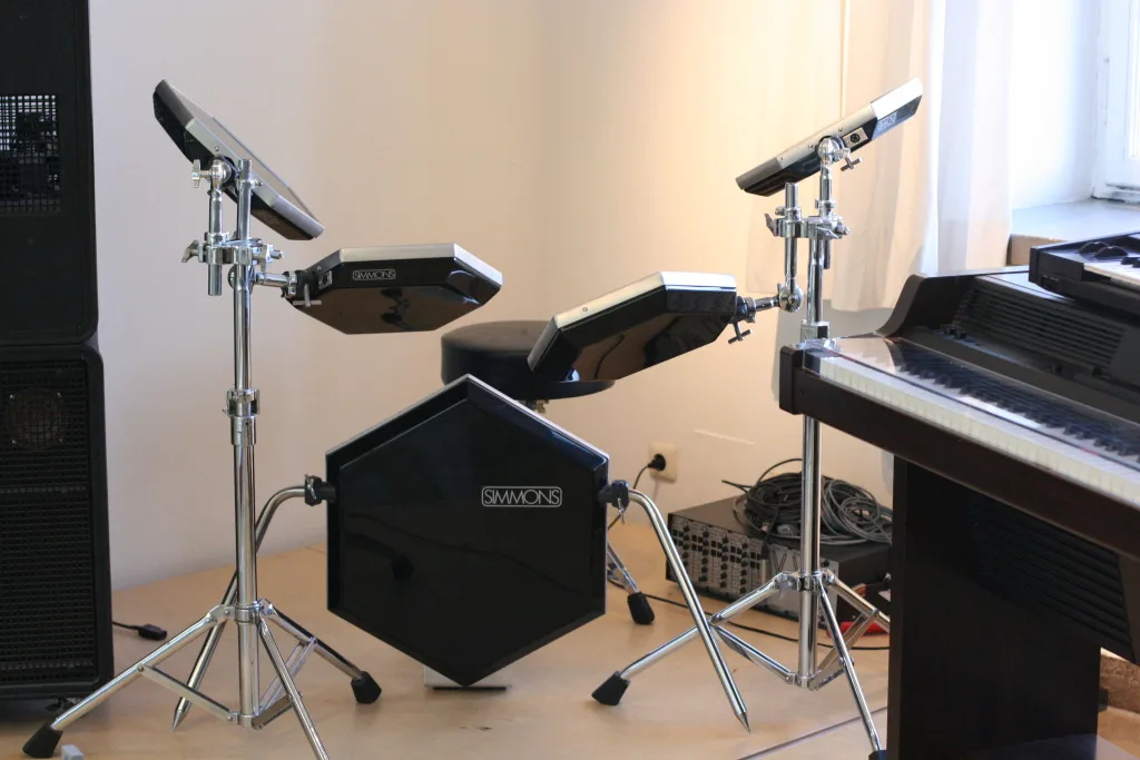 A Simmons SDS-5 electronic drum kit with its hexagonal pads on stands and the brain module beside it.