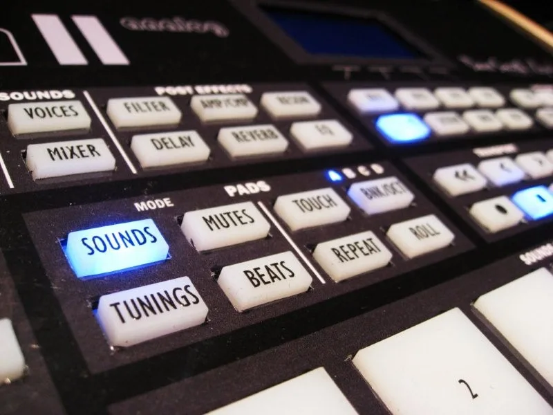 Close-up of the LinnDrum II prototype at the 2008 NAMM show: backlit white buttons labelled Sounds, Tunings, Mutes, Beats, Touch, Repeat and Roll, with the corner of a drum pad at the bottom.