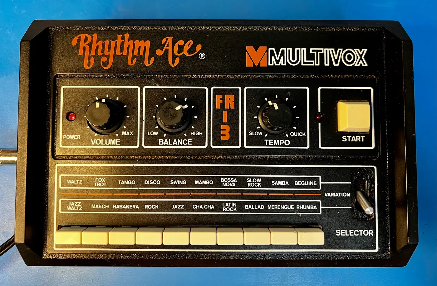 An Ace Tone rhythm box sold as the Multivox Rhythm Ace FR-3S, with Volume, Balance and Tempo knobs, a Variation switch and ten buttons for styles such as Waltz, Fox Trot, Bossa Nova and Rhumba.