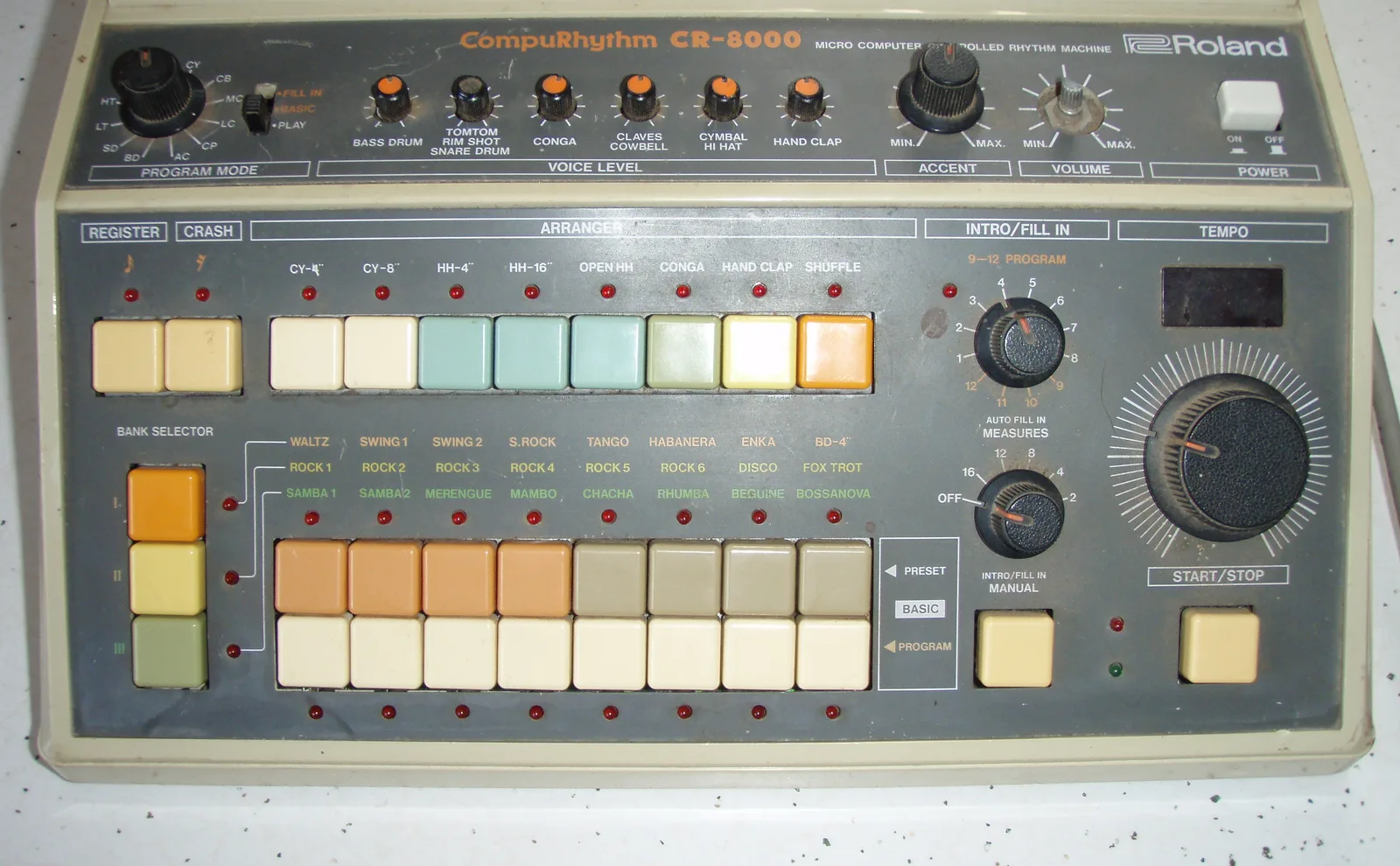 Front panel of a Roland CompuRhythm CR-8000, with six voice-level knobs, a row of Arranger buttons, a three-bank selector and two rows of rhythm buttons including Hand Clap.